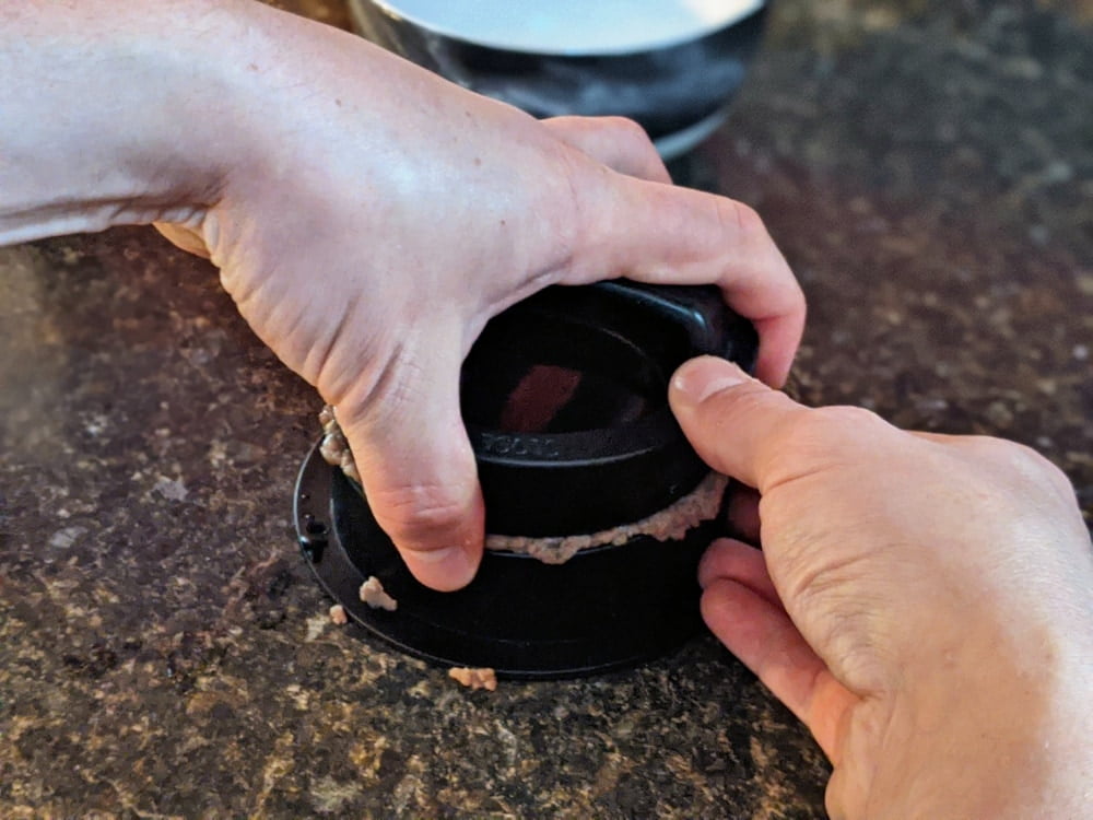 Wiping excess meat from stuffed burger patty